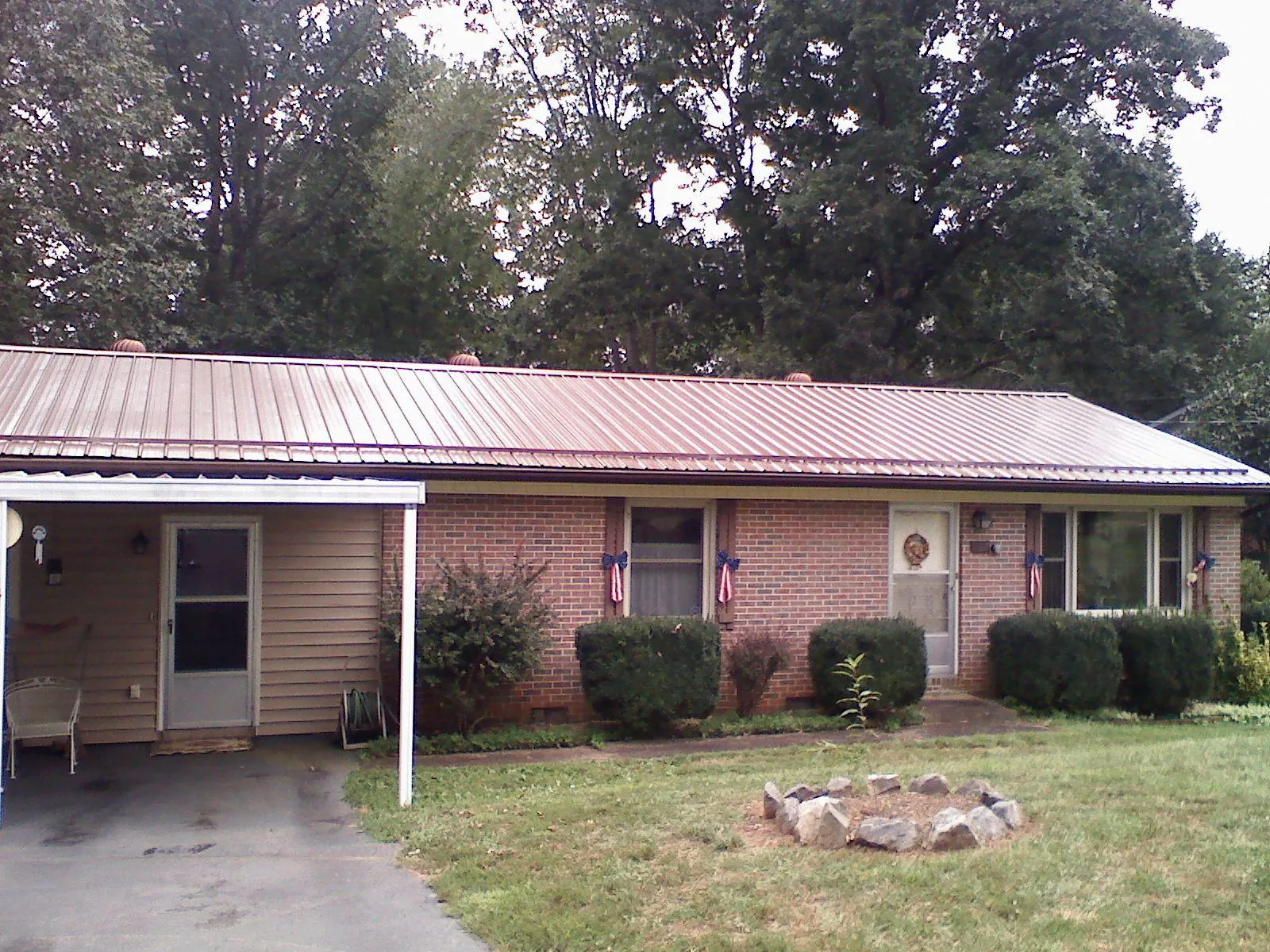 Bronze metal roof and carport on a brick ranch home — Roof Repair work by our crew in Claremont